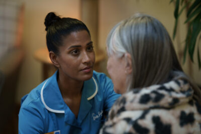 A Sue Ryder nurse looks at an older woman with an expression of care