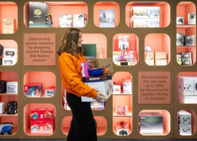 A woman carrying a pile of items at Amazon's Second Chance Store in London