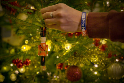 A still from Help for Heroes Christmas appeal film showing a hand putting a toy soldier back on the tree. The hand has a Help for Heroes wristband