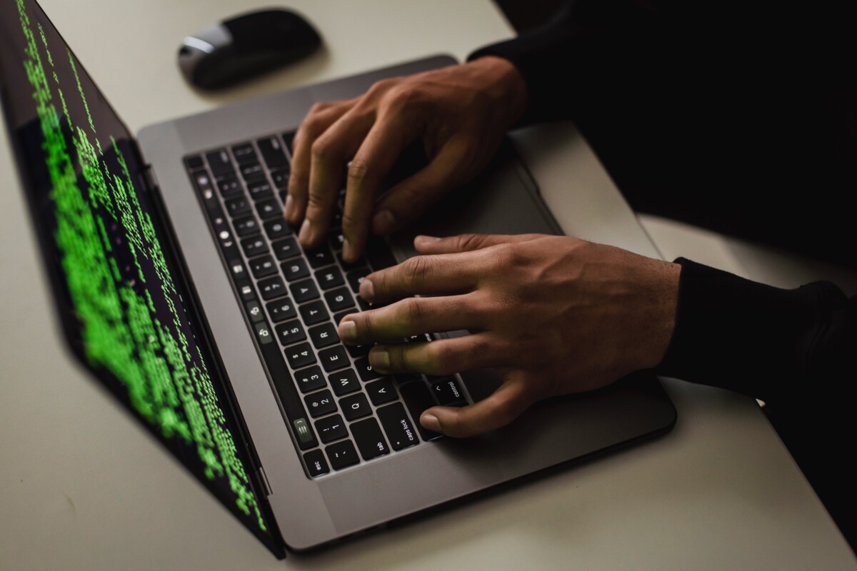 Hands at a computer, with the screen showing green data against a black background. By Sora Shimazaki on Pexrels