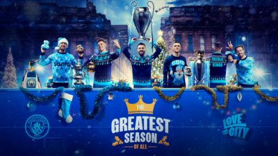 Man City players in blue with trophies and retail items as part of its Greatest Season of All campaign