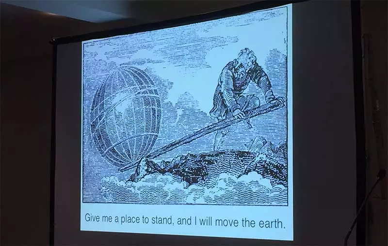 Give me a place to stand, and I shall move the earth. B/W print image displayed on a screen.