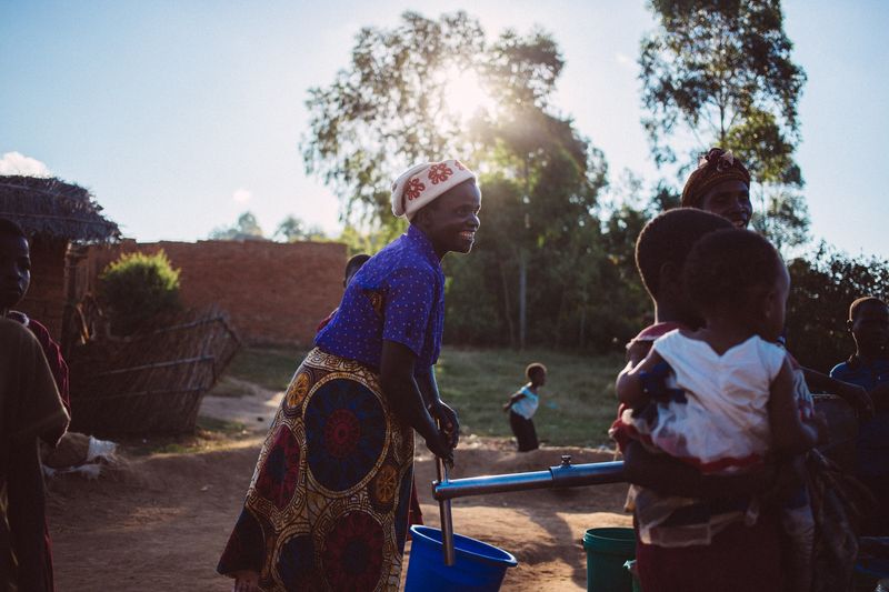 Violet draws water from a well, Malawi.