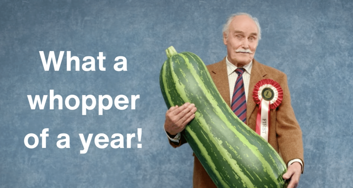 What a whopper of a year! An older man holds a giant marrow, and wears a winning rosette. Part of the Remember a Charity annual review video for 2023.