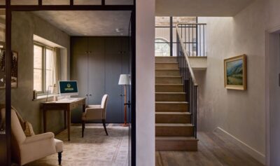 Interior shot of Omaze Cotswolds house showing stairs and an office room with armchairs