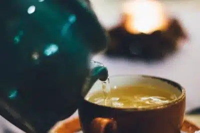 tea pours into a cup from a teapot. By Maria Tyutina on pexels