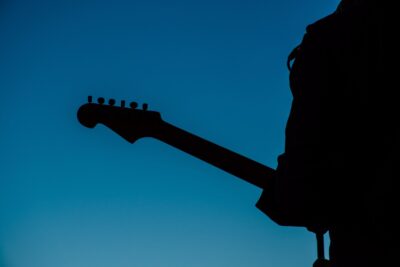 The silhouette of someone playing an electric guitar. by Brett Sayles on pexels