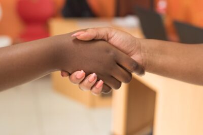 Two people of colour shake hands. By Cytonn Photography on pexels