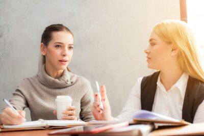 Two women talking at a table.