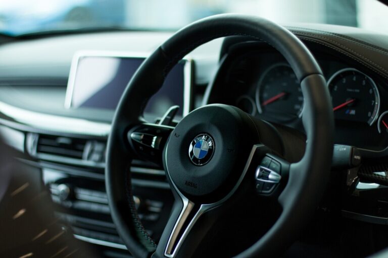 Interior shot of a BMW showing the steering wheel. By Toby Parsons on Pixabay