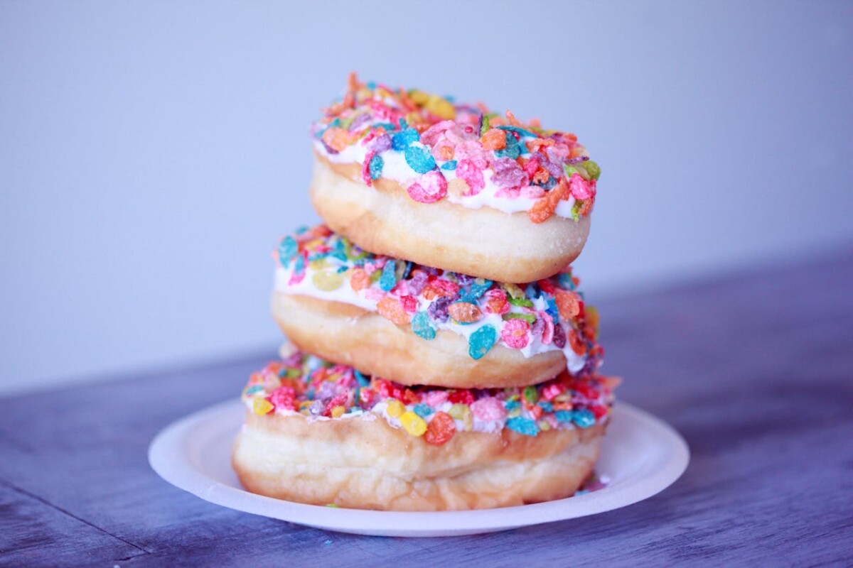 A stack of 3 doughnuts with icing and sprinkles. by Alexander Grey on Pexels
