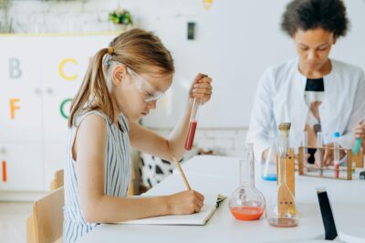 Two children concentrating as they conduct science experiments. By Mikhail Nilov on Pexels
