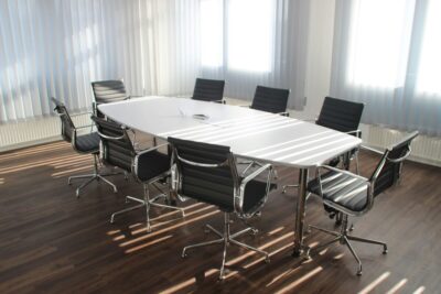 An empty meeting room with chairs around a table. By Pixabay on Pexels