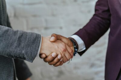two people in suits shake hands. By Olia Danilevich on Pexels