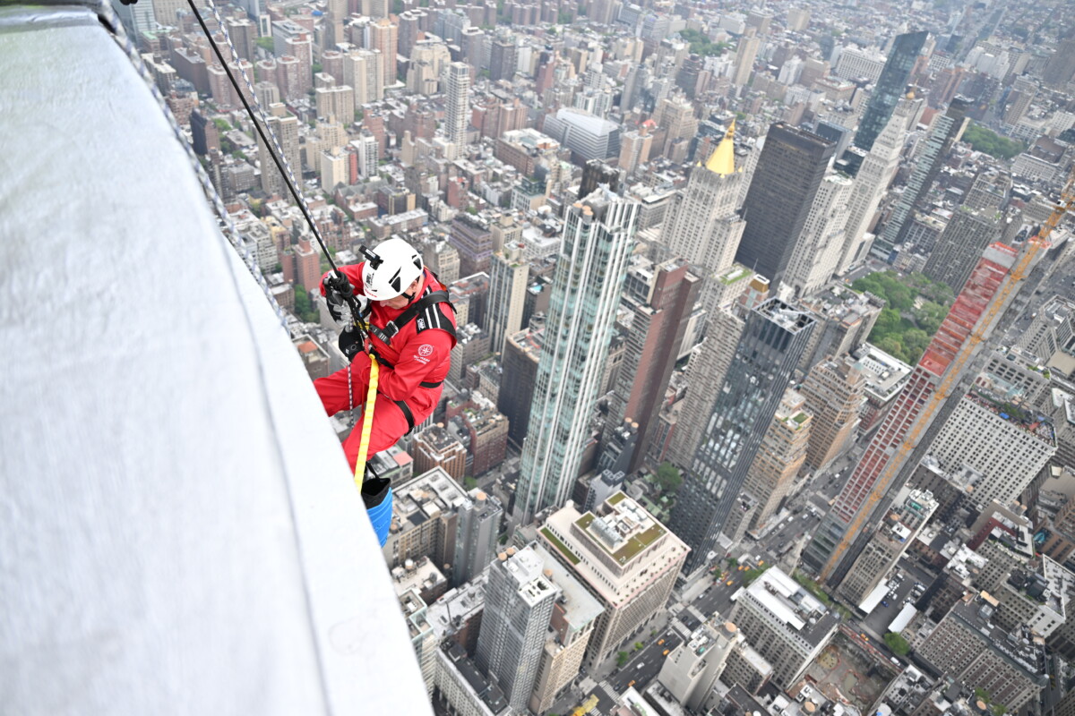 Over the edge. An abseiler begins the descent from the Empire State Building with New York City below.