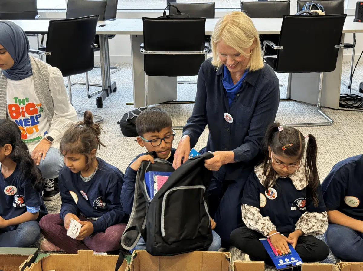 Anneka Rice packing schoolbags with Hand on Heart in Harefield