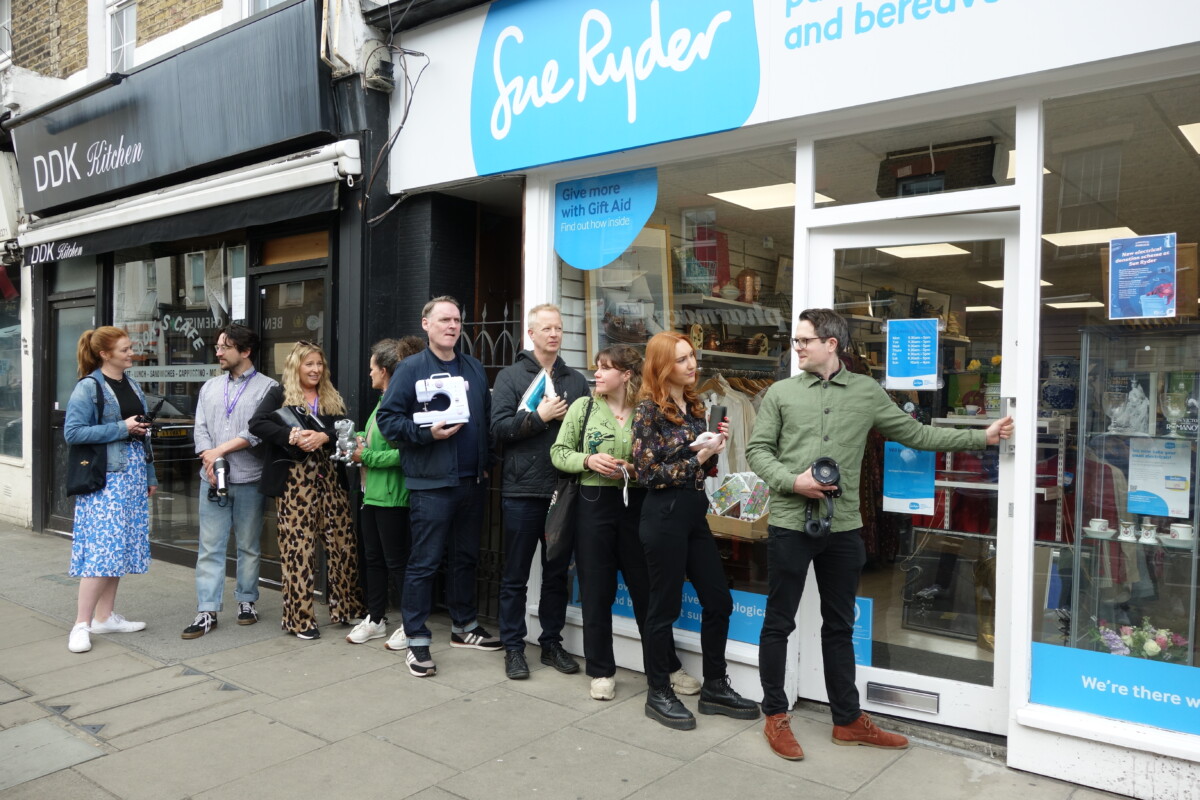 a queue of people outside a Sue Ryder shop