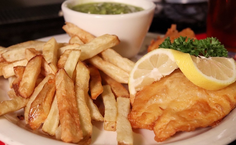 A close up of fish and chips on a white plate