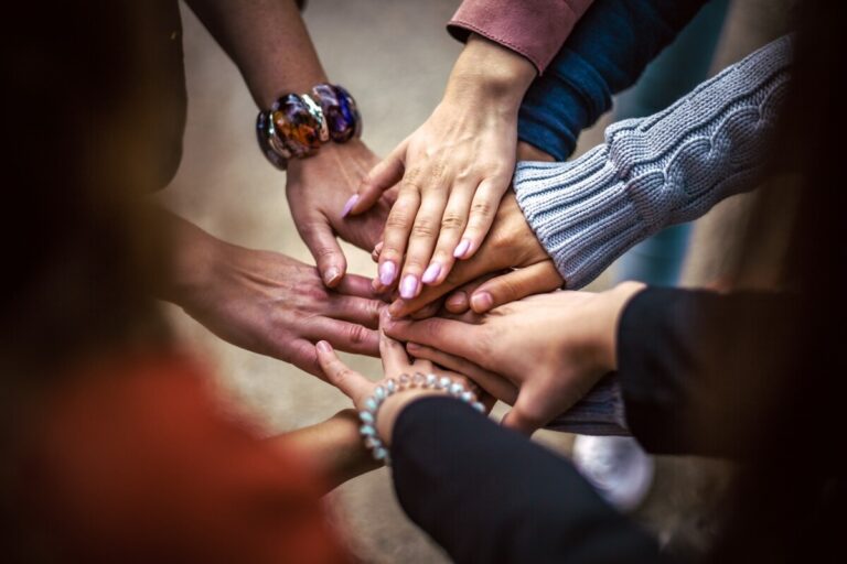 Hands reaching out and touching in a circle of people. By Bob Dmyt on Pixabay