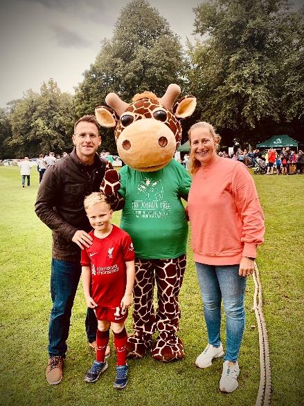 A family stand with a person in a giraffe costume.