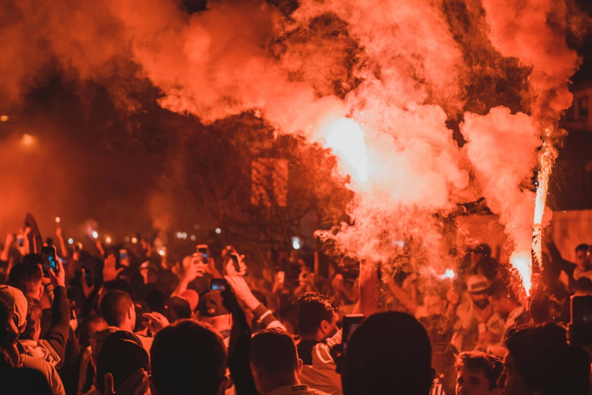 A picture of rioting at night with smoke and flames. By Maurício Mascaro on pexels