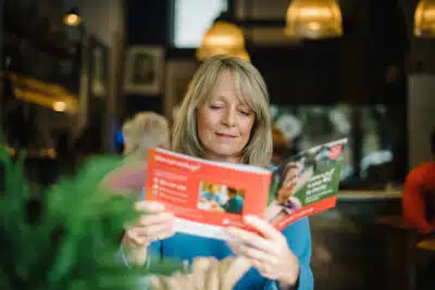 A woman reads a Salvation Army booklet about leaving a legacy in their will