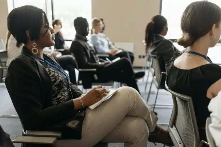 An audience of business people in a room. By Pavel Danilyuk on pexels