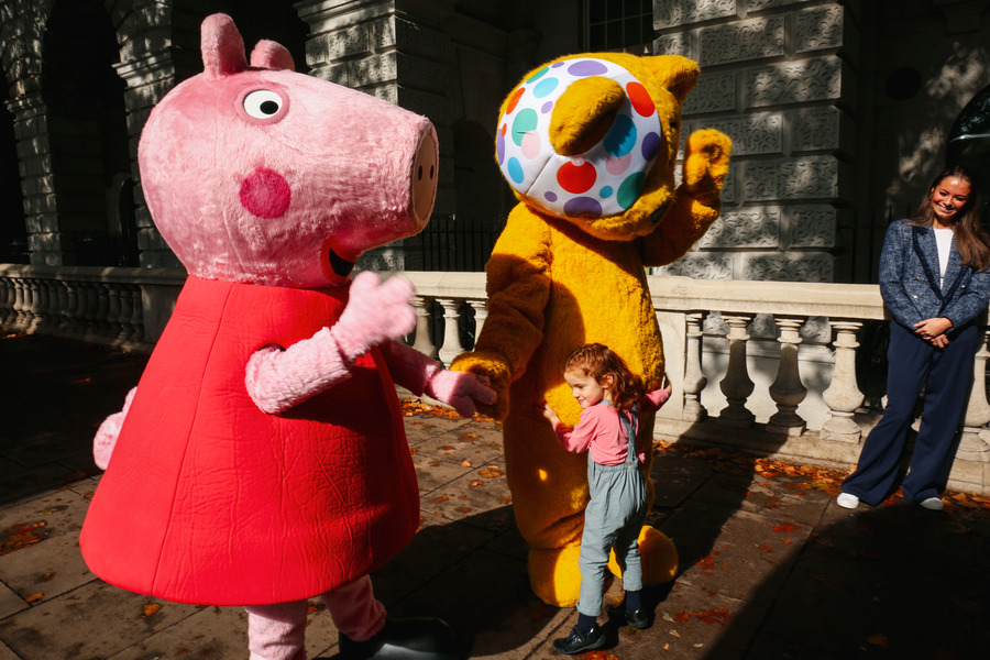 Peppa Pig and Pudsey on a meet and greet - a little girl hugs Pudsey