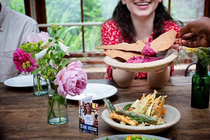 People pass food around a table