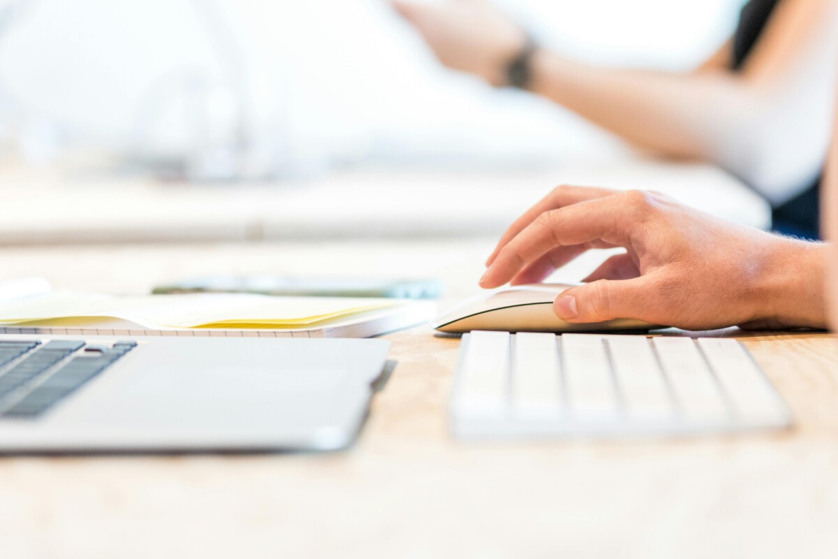 A hand moves a mouse next to their keyboard. By Lex Photography on pexels