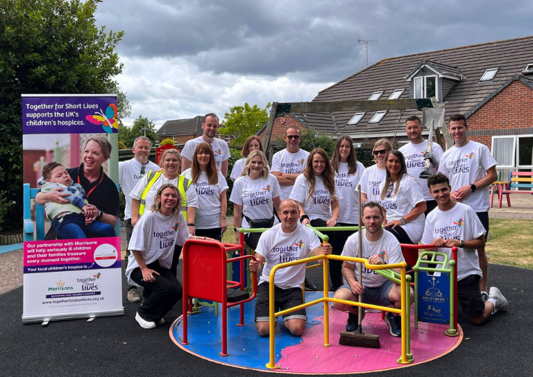 A group shot of people in Together for Short Lives t-shirts on and by a playground roundabout