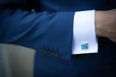 Close up of a man's arm in a blue suit showing his shirt cuff and cufflink. By Rene Terp on Pexels