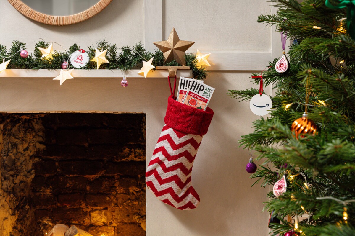 Figs in Blankets chocolate bars in a stocking hanging on a christmas decorated mantlepiece