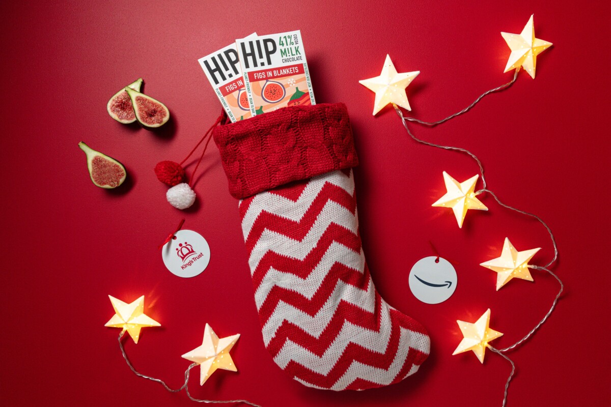 Figs in Blankets christmas chocolate in a red and white stocking against a red background