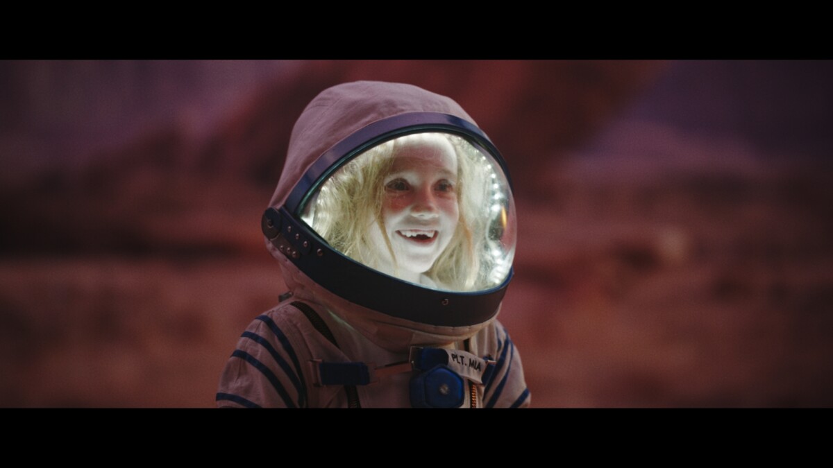 A young girl smiles in a space suit - a still from Shelter's 2024 Christmas appeal film