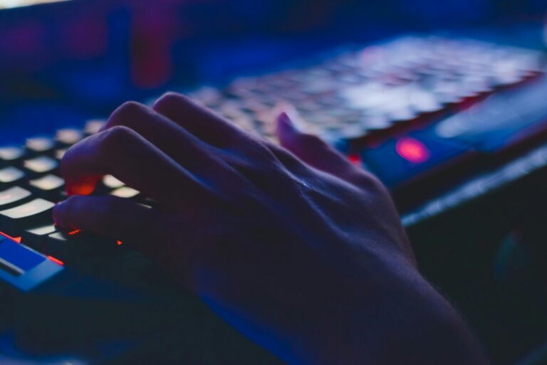 A hand on a keyboard in the dark. By Soumil Kumar on Pexels