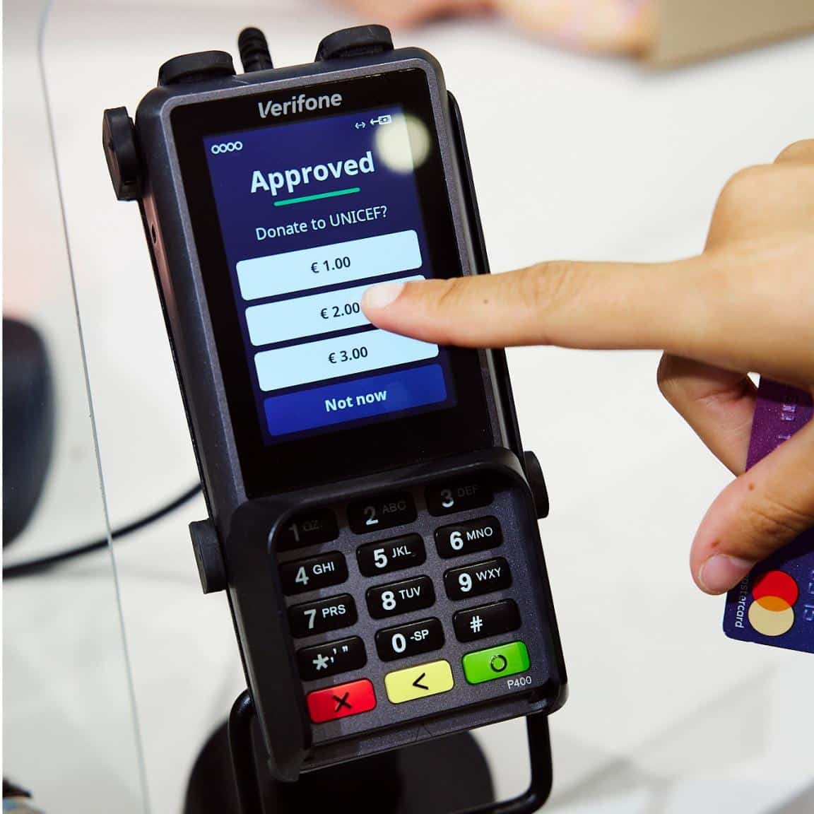 Adyen store checkout device inviting donations for Unicef. A shopper is about to choose the middle suggested amount.