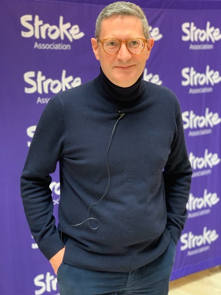 Jason Parker stands in front of Stroke Association logos