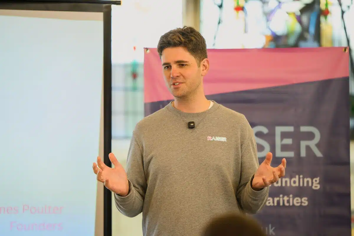 Luke Wilkinson at the launch of Raiser in Buxton pump room. A Raiser banner is behind him