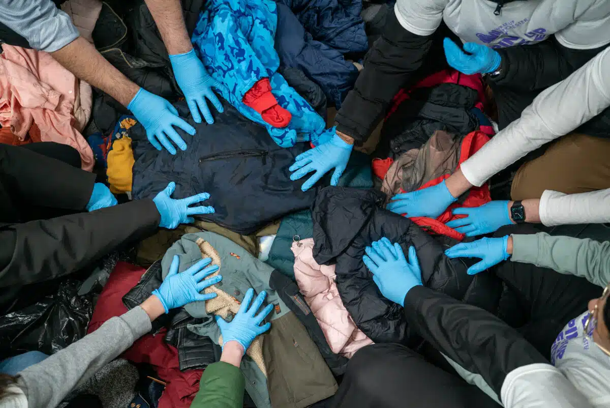 Overhead view of donated Winter clothes being sorted by hand