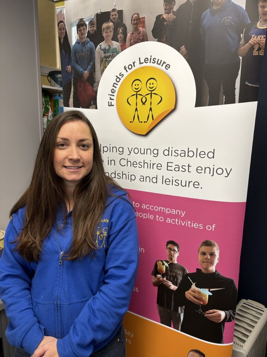 Amanda Hunt in front of a Friends for Leisure poster