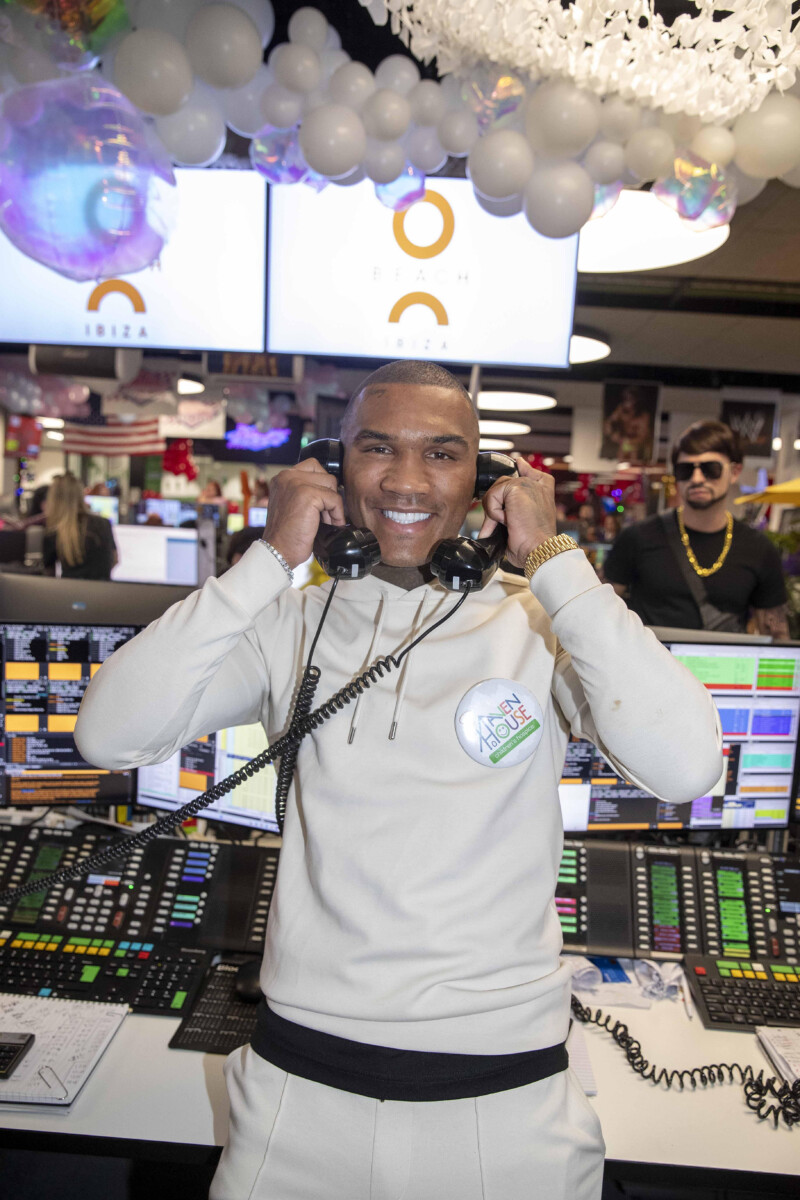 Conor Benn, holding two corded phones, at ICAP Charity Day in London.