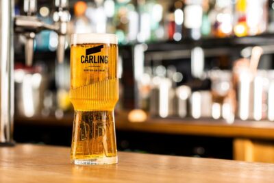 A pint of Carling in a fundraising collecting tin-shaped pint glass.