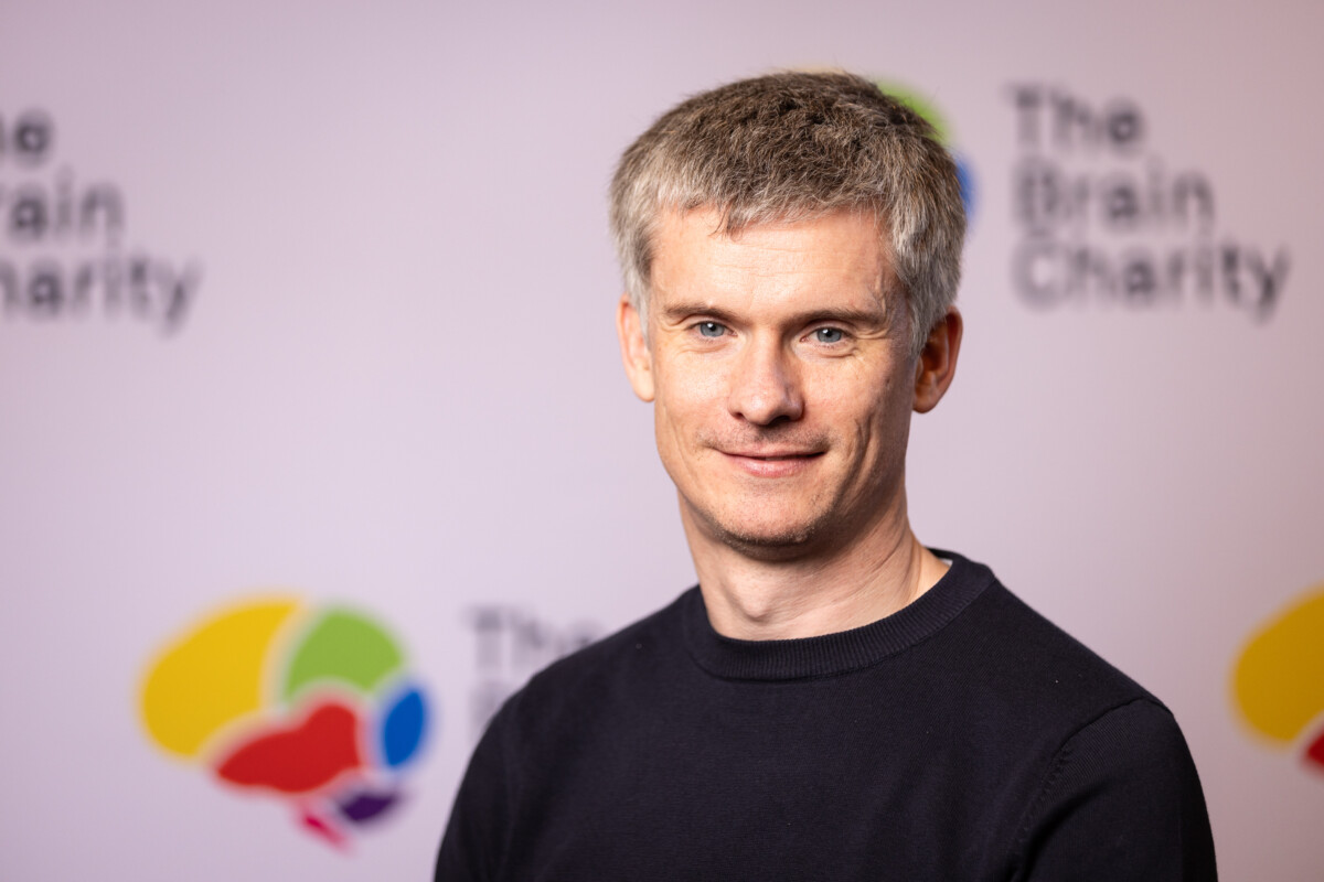 Matt Meaney with The Brain Charity logo behind him