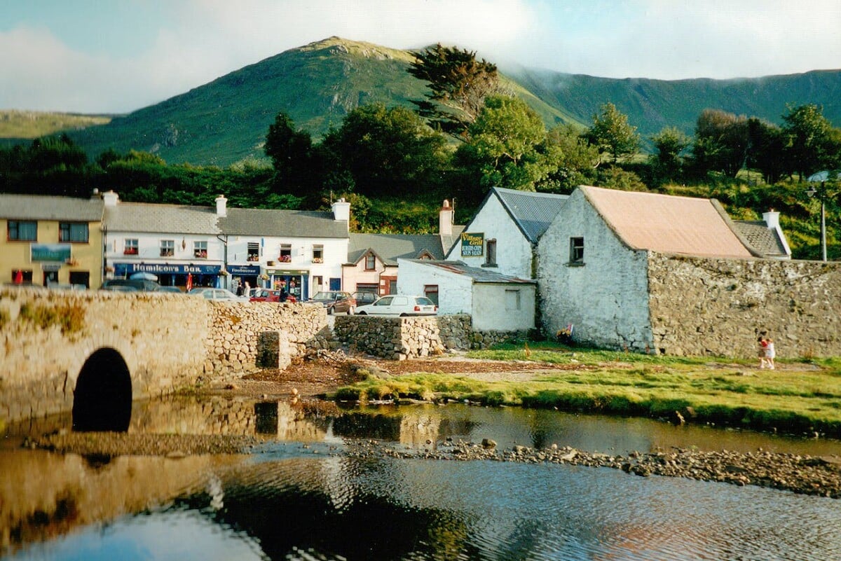 Village in Ireland with a stone bridge over a river.