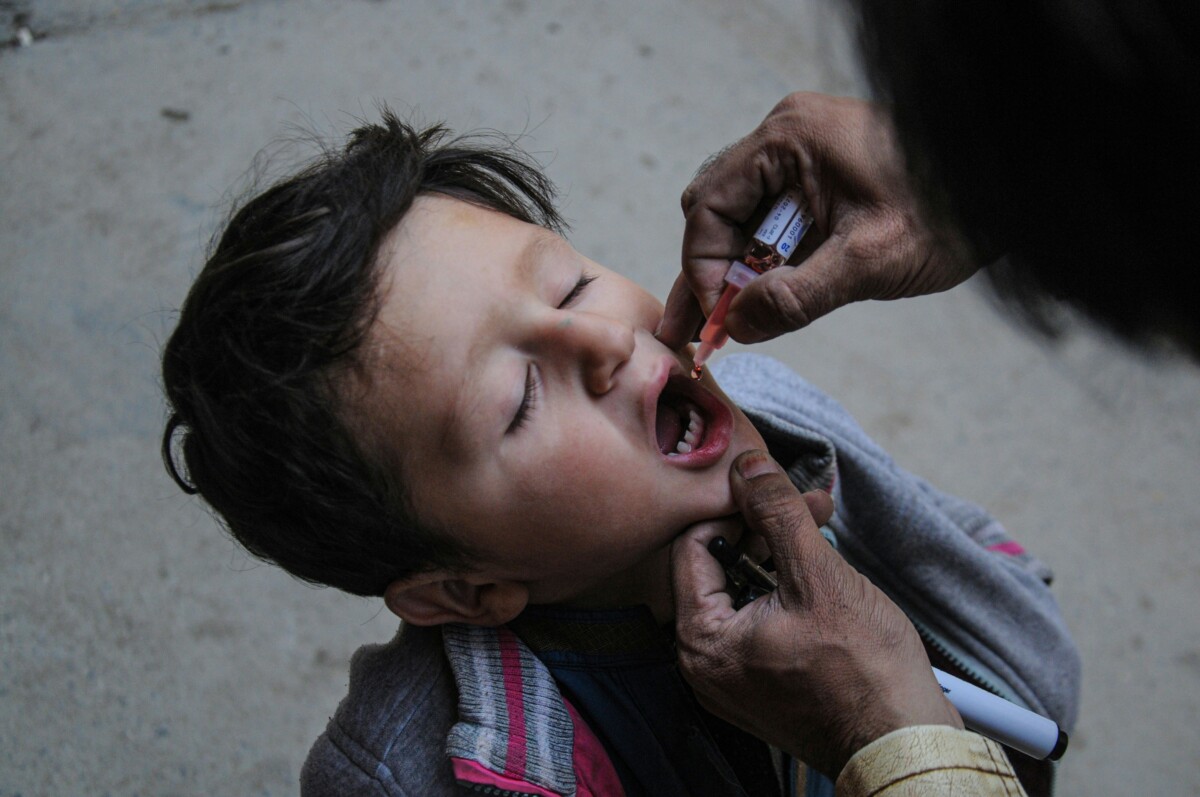 A health worker administers polio vaccine to a child during an anti-polio drive in Rawalpindi on 13 December 2021.